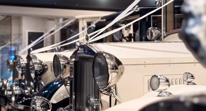 Ivory and navy Imperial wedding cars lined up inside the Keyhole Motors showroom